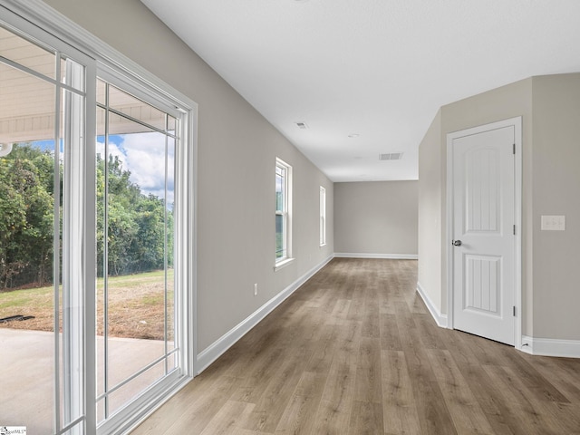 empty room with light hardwood / wood-style flooring and a healthy amount of sunlight