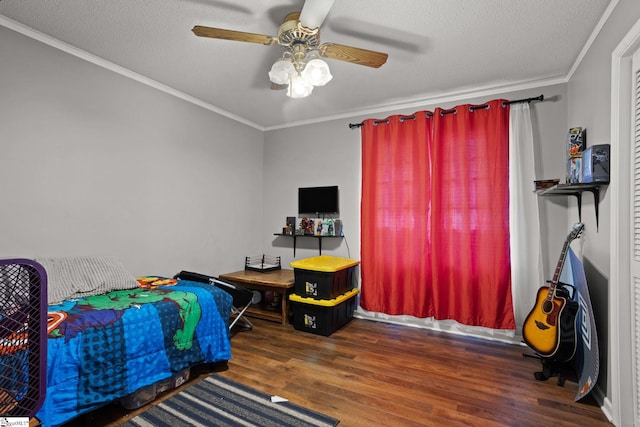 bedroom featuring a textured ceiling, ornamental molding, dark wood-type flooring, and ceiling fan