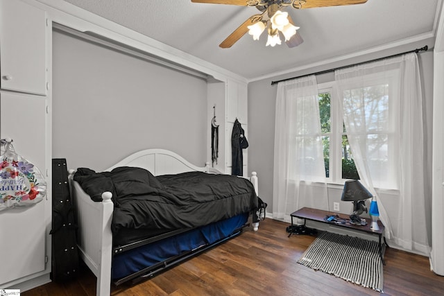 bedroom featuring a textured ceiling, ceiling fan, crown molding, and dark hardwood / wood-style flooring