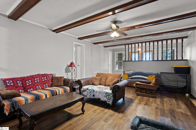 living room with a textured ceiling, beam ceiling, hardwood / wood-style floors, and ceiling fan