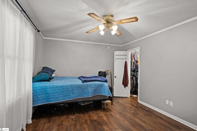 bedroom featuring dark wood-type flooring, a closet, a textured ceiling, ceiling fan, and ornamental molding