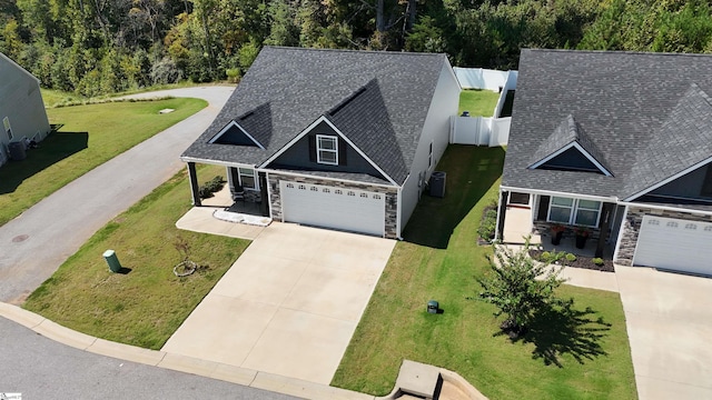 view of front of property featuring cooling unit, a front lawn, and a garage