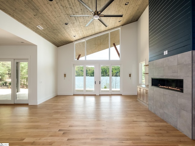 unfurnished living room featuring ceiling fan, wooden ceiling, high vaulted ceiling, and a tile fireplace