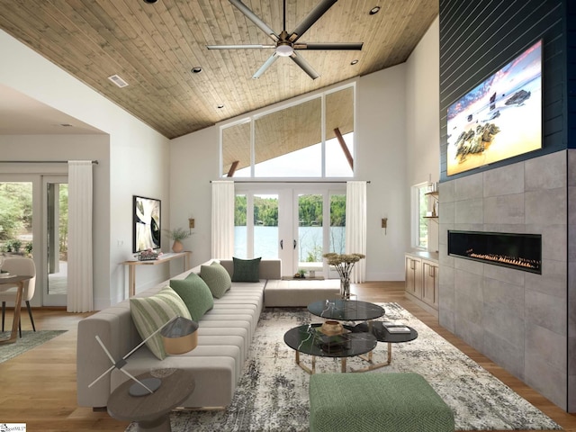 living room with wood ceiling, a high ceiling, a tiled fireplace, and ceiling fan