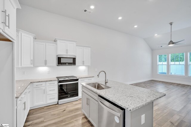 kitchen featuring sink, vaulted ceiling, appliances with stainless steel finishes, decorative backsplash, and white cabinets