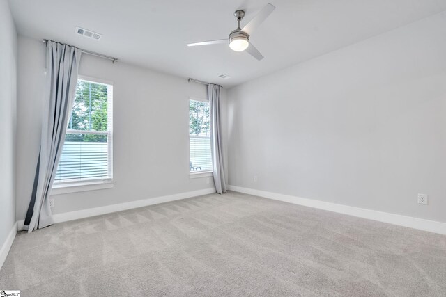 empty room featuring light colored carpet and ceiling fan