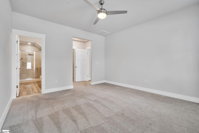 unfurnished bedroom featuring vaulted ceiling, light colored carpet, ceiling fan, and ensuite bathroom