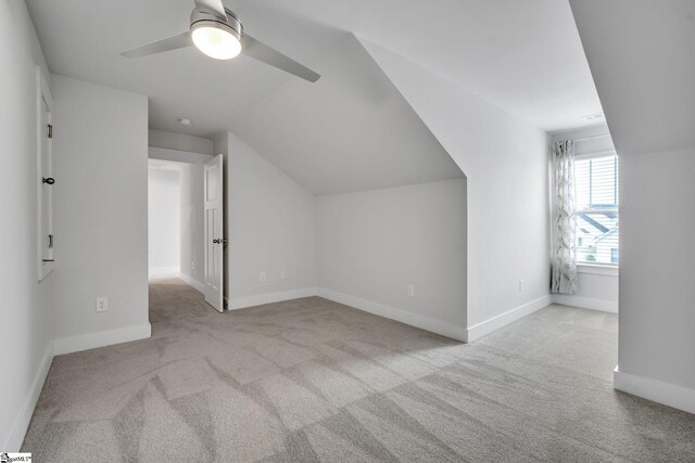 bonus room with lofted ceiling, light carpet, and ceiling fan