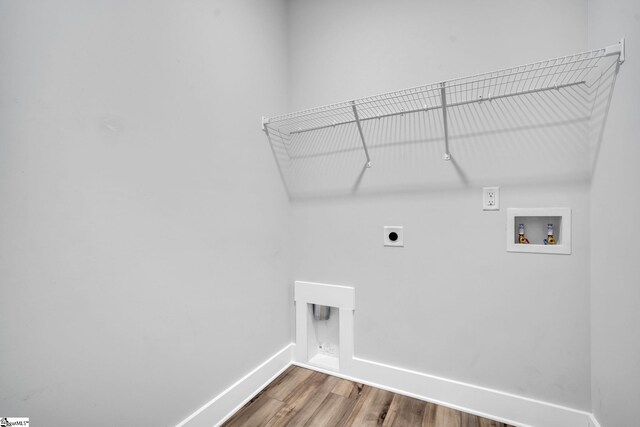 clothes washing area featuring hardwood / wood-style flooring, hookup for an electric dryer, and hookup for a washing machine