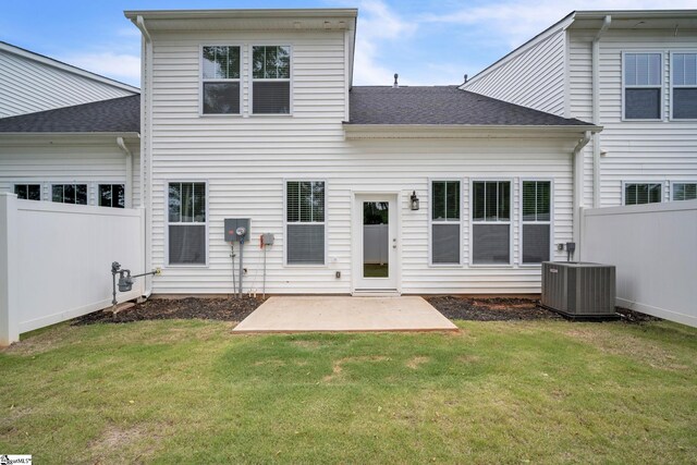 back of property featuring a lawn, central air condition unit, and a patio area