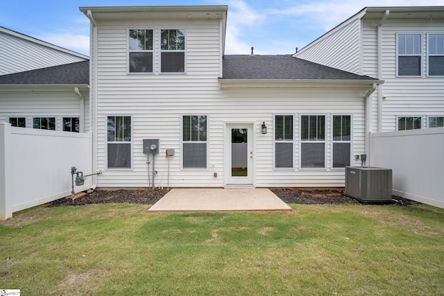 rear view of property with a yard, central AC unit, and a patio area