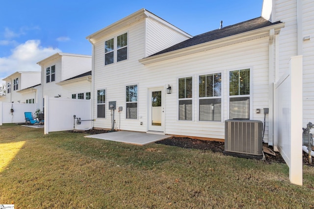 back of house with central AC, a patio, and a lawn