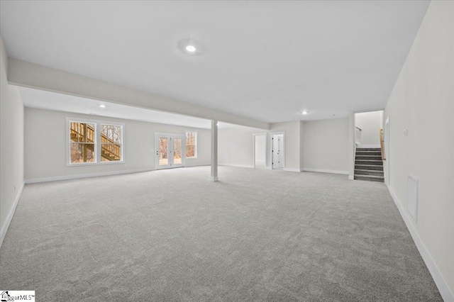 basement with french doors and light carpet