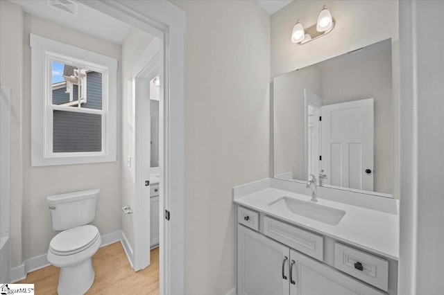 bathroom with vanity, toilet, and wood-type flooring