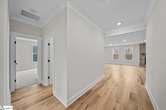 hall with crown molding and light wood-type flooring