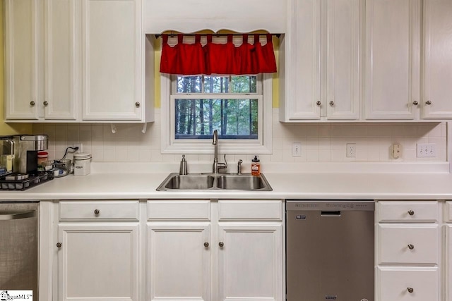 kitchen featuring tasteful backsplash, sink, white cabinetry, and stainless steel dishwasher