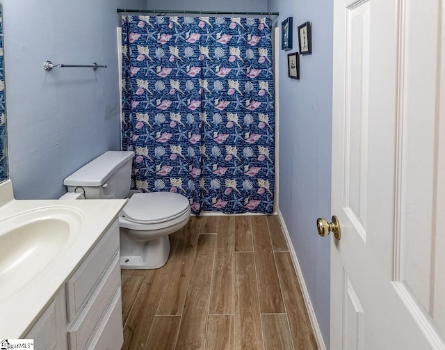 bathroom featuring vanity, a shower with curtain, hardwood / wood-style floors, and toilet