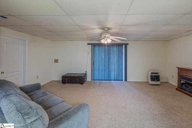 carpeted living room with ceiling fan, heating unit, and a drop ceiling