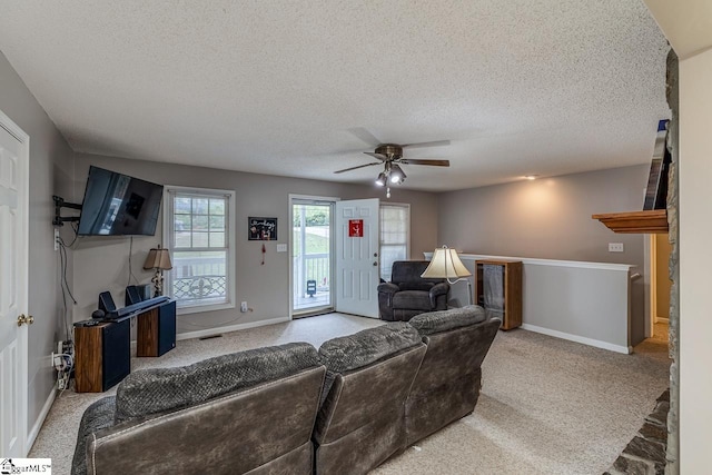 living room featuring a textured ceiling, carpet, and ceiling fan