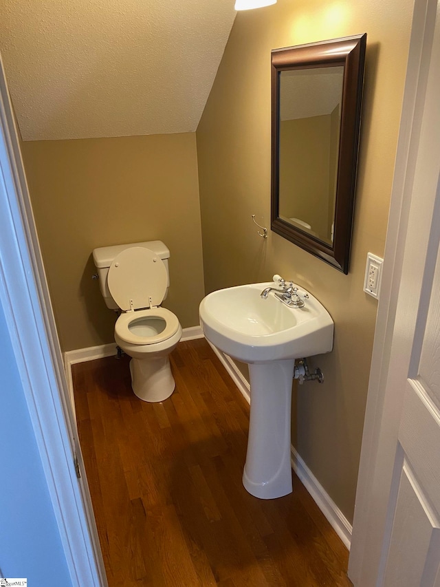 bathroom featuring wood-type flooring, a textured ceiling, and toilet