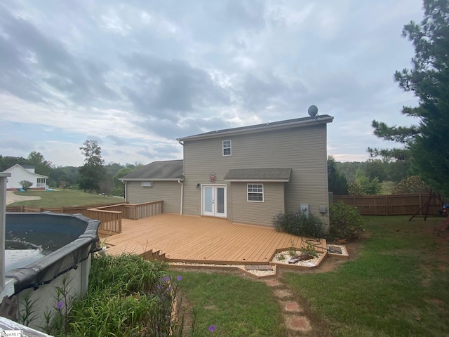 back of property with a lawn and a pool side deck