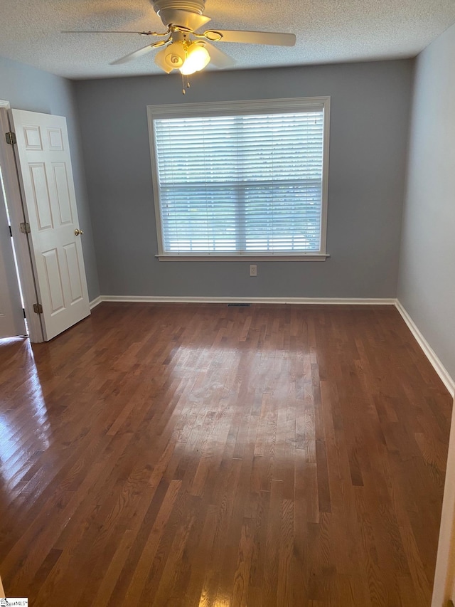 unfurnished room featuring ceiling fan, a textured ceiling, and dark wood-type flooring