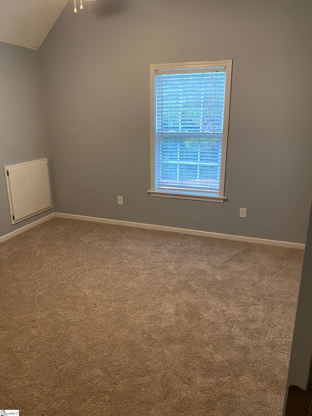 empty room with carpet floors and lofted ceiling