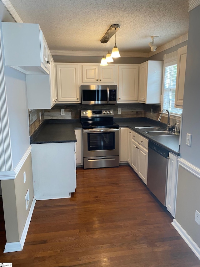 kitchen with dark wood-type flooring, white cabinetry, hanging light fixtures, stainless steel appliances, and backsplash