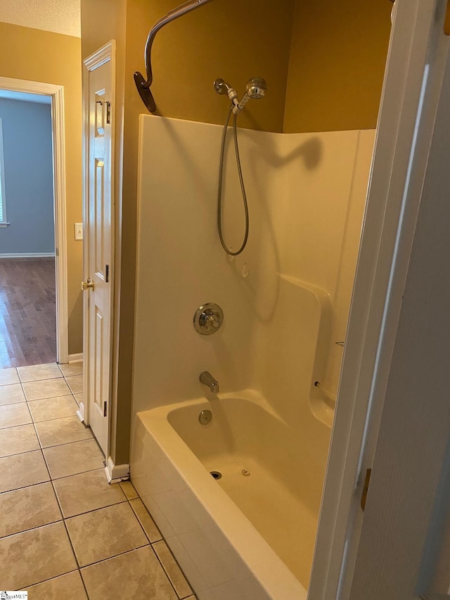 bathroom featuring tile patterned flooring and  shower combination