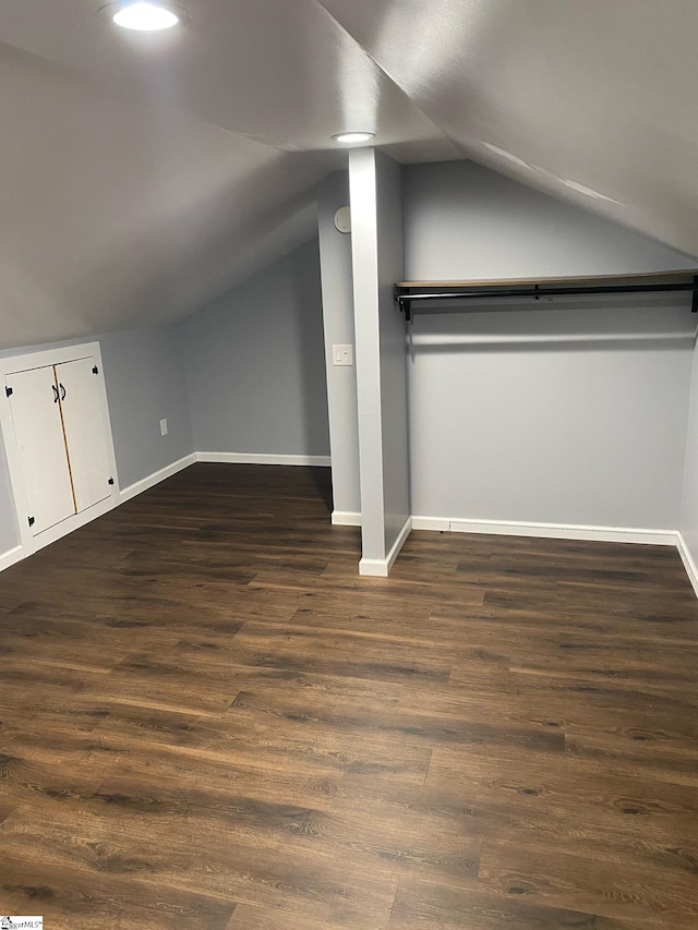 bonus room with dark hardwood / wood-style floors and vaulted ceiling