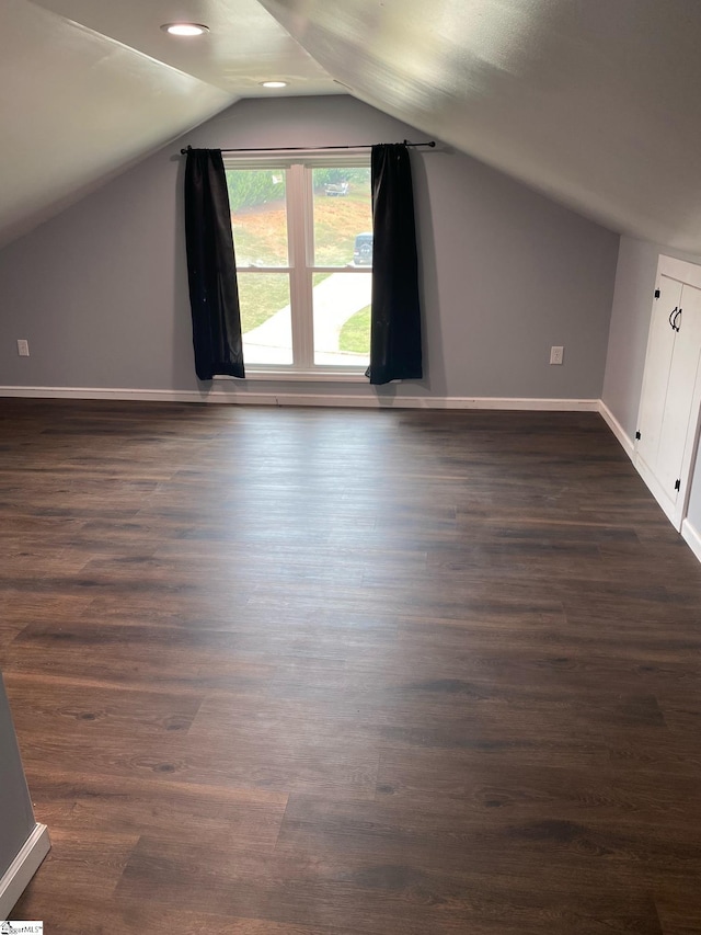 additional living space with vaulted ceiling and dark hardwood / wood-style floors