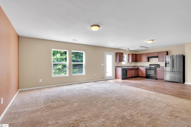 kitchen with black appliances, carpet flooring, and sink