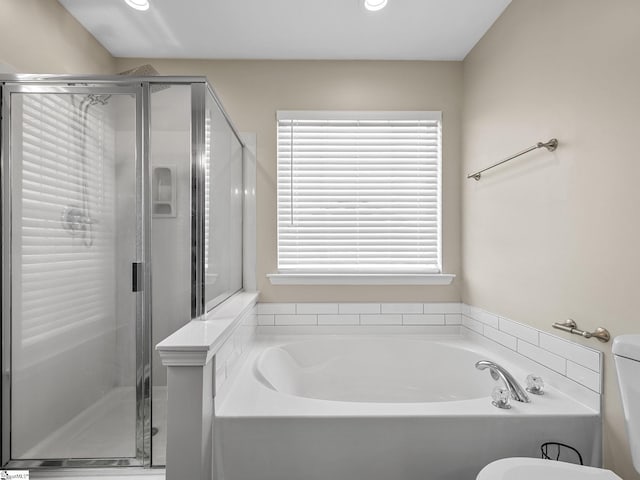 bathroom featuring shower with separate bathtub and toilet