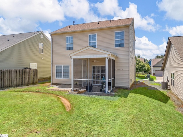 rear view of house featuring a sunroom, central air condition unit, and a lawn