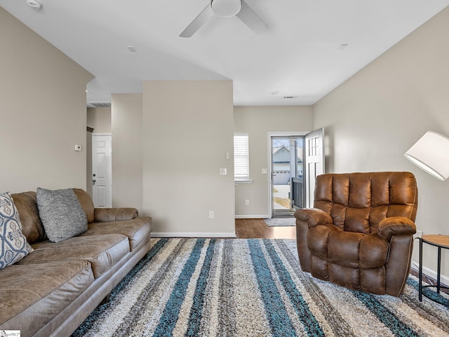 living room with wood-type flooring and ceiling fan