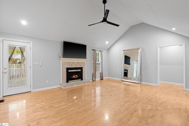 unfurnished living room with vaulted ceiling, ceiling fan, plenty of natural light, and a fireplace