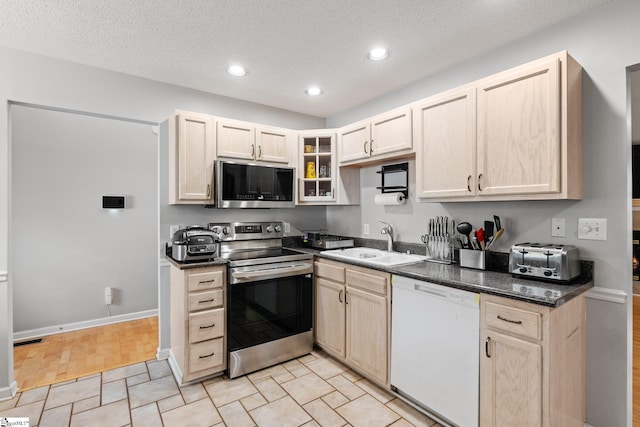 kitchen with appliances with stainless steel finishes, a textured ceiling, and sink