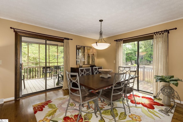 dining room with a textured ceiling, crown molding, and hardwood / wood-style flooring