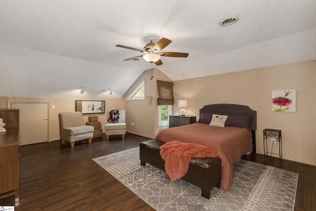 bedroom featuring vaulted ceiling, ceiling fan, dark wood-type flooring, and a textured ceiling