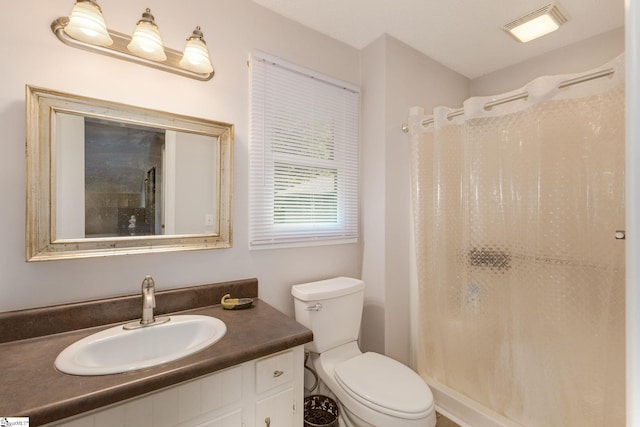 bathroom featuring walk in shower, vanity, and toilet