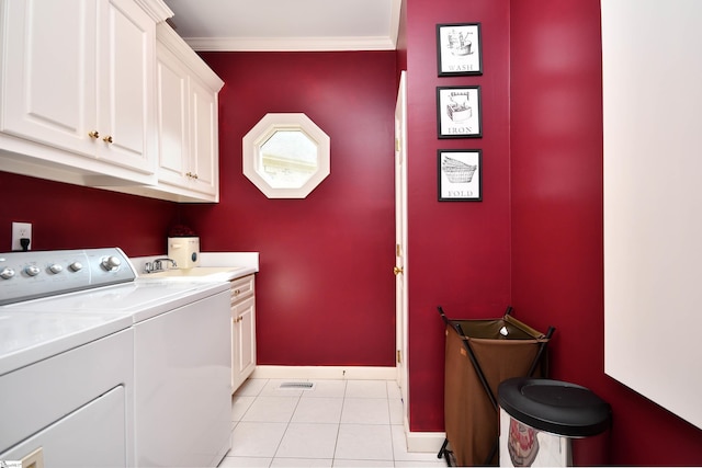 laundry area featuring light tile patterned flooring, sink, ornamental molding, cabinets, and separate washer and dryer