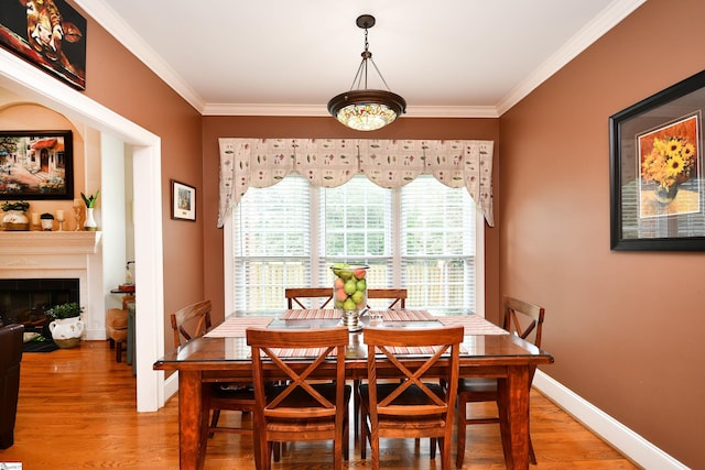 dining space with hardwood / wood-style flooring and ornamental molding