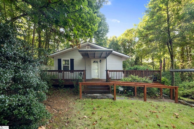 back of property with a wooden deck and a lawn