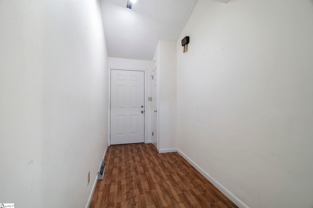 hall with vaulted ceiling and dark hardwood / wood-style flooring