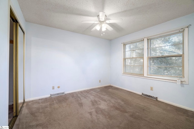 unfurnished bedroom featuring a closet, ceiling fan, carpet flooring, and a textured ceiling