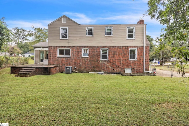 rear view of property featuring a yard and central air condition unit