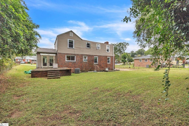 back of property featuring a lawn, central air condition unit, and french doors