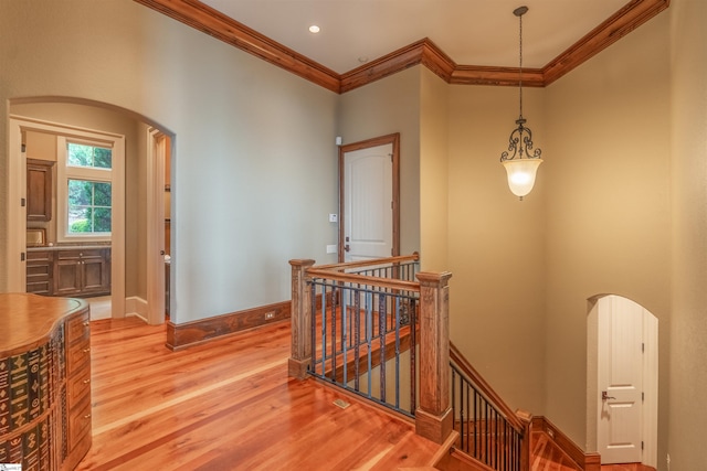 hallway featuring ornamental molding and light hardwood / wood-style floors