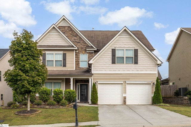 craftsman inspired home featuring cooling unit, a front yard, and a garage