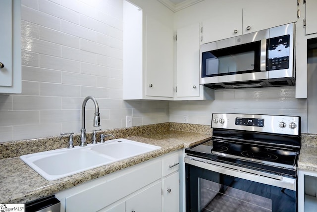 kitchen with white cabinetry, backsplash, stainless steel appliances, ornamental molding, and sink